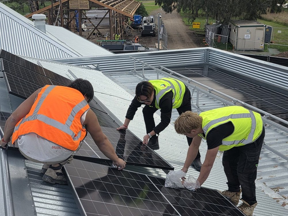 E3 Energy crew laying solar panels on a metal roof in Victoria