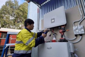 E3 Energy installer commissioning a Fox ESS hybrid inverter and battery, the kind of solar and battery system that cuts grid electricity use on a Melbourne power bill