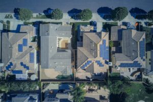 Aerial view of a row of suburban houses with rooftop solar panels, the kind of homes that can be linked into a virtual power plant